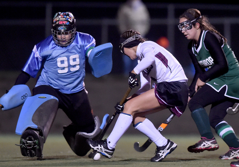 Winthrop goalie Corinna Coulton (99) makes a save on a shot from Maine Central Institute's Madisyn Hartley, center, in the Class C North final Wednesday in Hampden.