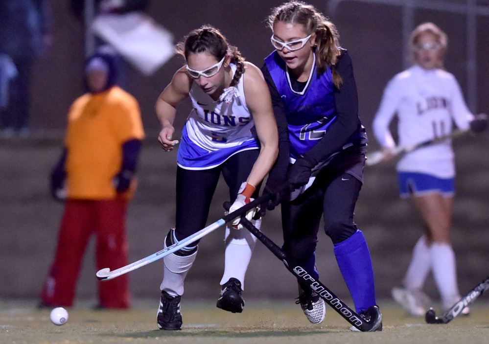 Lawrence's Nora Buck battles for the ball with Belfast's Amy Gaiero during the Class B North final against Belfast on Wednesday night Hampden Academy.