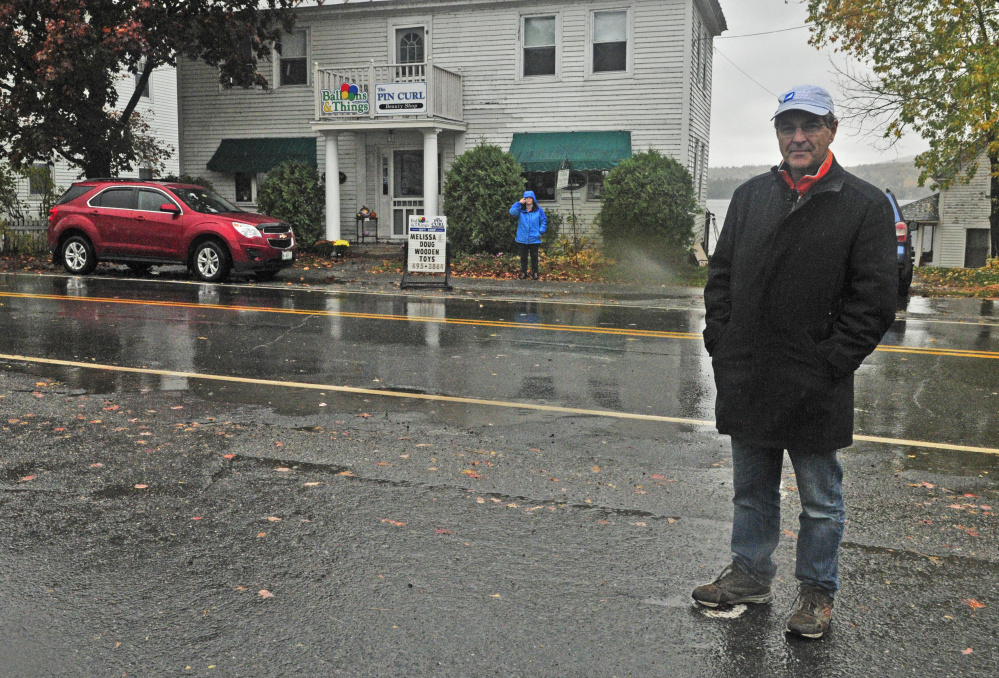 Jan Partridge, left, and Patrick Donahue stand near where a proposed crosswalk will be located between Partridge's businesses, Balloons & Things and Pincurl Beauty Shop, and the Maine Lakes Resource Center Annex, where Donahue works, in Belgrade Lakes village.