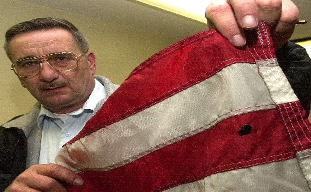 Pittsfield police Chief Steven Emery, shown in 2012, holds an American flag that allegedly was vandalized by a teenager. The flag had been on display outside Reny's department store in Pittsfield. Emery died unexpectedly Saturday after more than 22 years as chief.