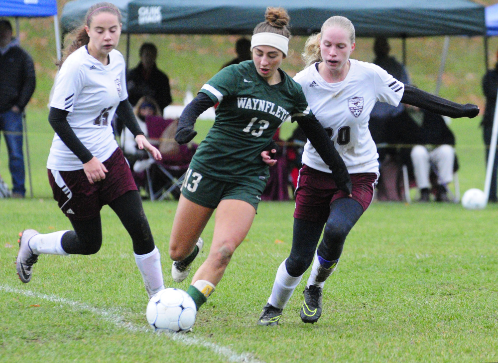 Waynflete's Amelia Bertaska (13) is flanked by Monmouth's Kayla Brooks, left, and Izzy Lewis during a Class C South semifinal game Saturday in Monmouth.