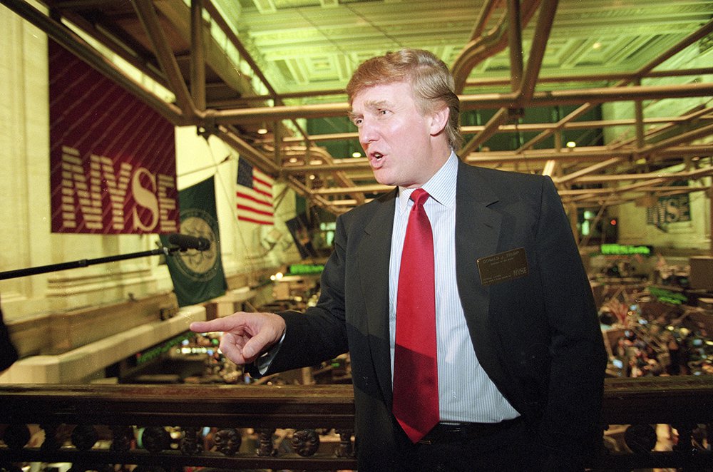 Donald Trump poses for photos above the floor of the New York Stock Exchange after taking his flagship Trump Plaza Casino public in New York City on June 7, 1995.  <em>Kathy Willens/Associated Press</em>