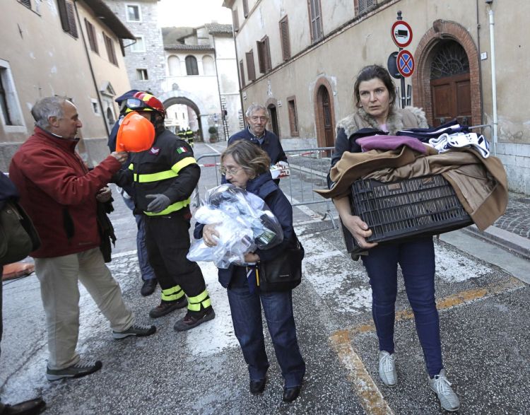Residents carry some of their belongings in the small town of Visso in central Italy Thursday, after a 5.9-magnitude earthquake destroyed part of the town. A pair of strong aftershocks shook central Italy late Wednesday, crumbling churches and buildings, knocking out power and sending panicked residents into the rain-drenched streets just two months after a powerful earthquake killed nearly 300 people. <em>Associated Press/Alessandra Tarantino</em>