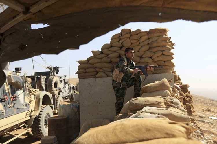 An Kurdish Peshmerga fighter stands guard outside Bartella, Iraq, Friday. Bartella is a historically Christian town about 9 miles  from Mosul's outskirts. <em>Associated Press/Khalid Mohammed</em>