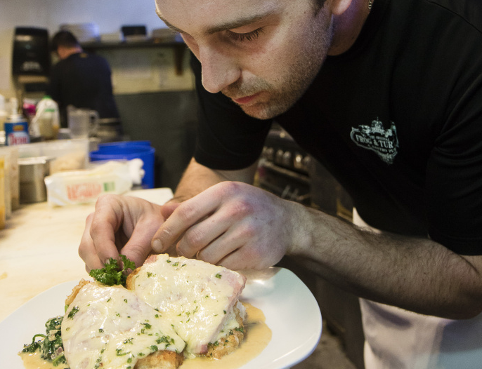 Chef J.P. Dubois, of the Frog & Turtle in Westbrook, garnishes a plate of chicken cordon bleu.