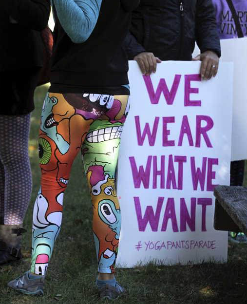 A woman in yoga pants joins others gathering at a starting point before marching in Barrington, R.I., on Sunday. 
Associated Press