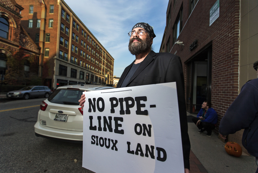 Chris Thompson of Portland protests outside Hillary Clinton's Portland campaign office Wednesday against the Dakota Access Pipeline. The Democrat's campaign last week issued a statement calling for "all voices" to be heard, but demonstrators want her to take a stronger stand against the situation in the Midwest.