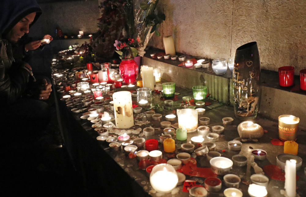 A man pays his respects Sunday at the Place de la Republique in Paris, France, after ceremonies honoring the victims of last year's Paris attacks that targeted the Bataclan concert hall and other sites. 