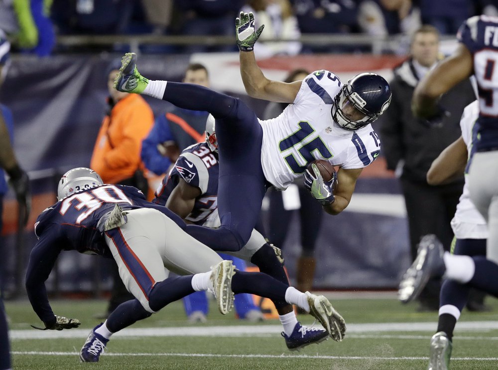 Seattle wide receiver Jermaine Kearse is upended by Patriots defensive backs Duron Harmon, left, and Devin McCourty after making a catch.