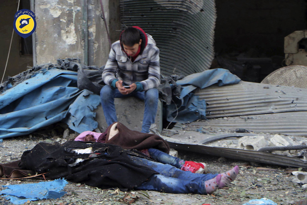 A Syrian boy sits beside bodies after artillery fire struck eastern Aleppo, Syria, on Wednesday. Fighters on both sides will do anything to gain military advantage, a U.N. chief says.