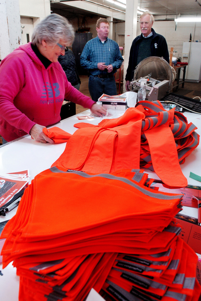 U.S. Sen. Angus King, I-Maine, right, watches as Maine Stitching Specialties employee Alice Quirion works on a safety dog vest Tuesday at the Skowhegan company as owner Bill Swain speaks about the company products.