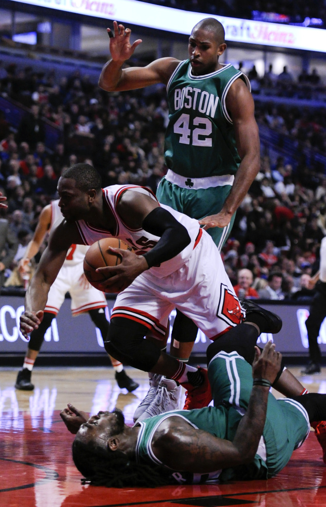 Chicago Bulls' Dwyane Wade, center, is called for an offensive foul against Celtics forward Jae Crowder (99) as Celtics center Al Horford (42) looks on during the second quarter of a game last Thursday in Chicago.