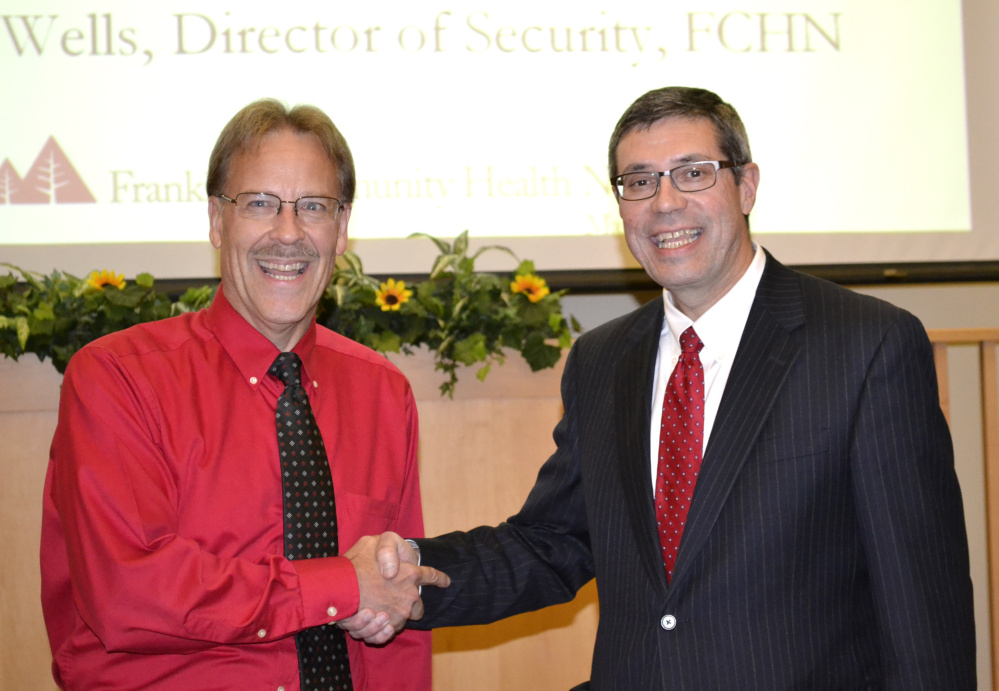 Roger Wells, left, director of security, receives the Franklin Community Health Leadership Award from board chairman Clinton Boothby.