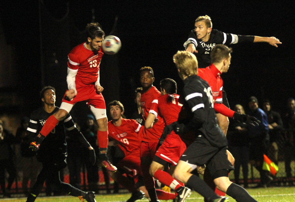 Thomas College's Adam LaBrie, upper right, watches as New England College's Michael Skarbelis heads a free kick away from the goal in the waning moments of regulation during the North Atlantic Conference championship in Waterville on Saturday night.