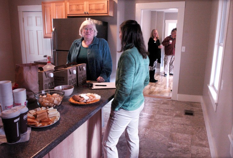 Waterville Community Land Trust board member Ricia Hyde, left, speaks with organization President Ashley Pullen on Sunday during an open house at a home on Water Street in Waterville that the organization renovated and is offering for sale.