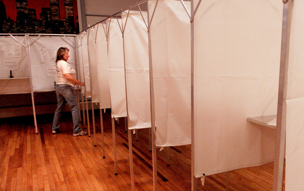 Dacia Rancourt fills the dozens of voting booths with instructions at the American Legion hall in Waterville on Monday, in preparation for Election Day. "They are empty now but not for long," Rancourt said.