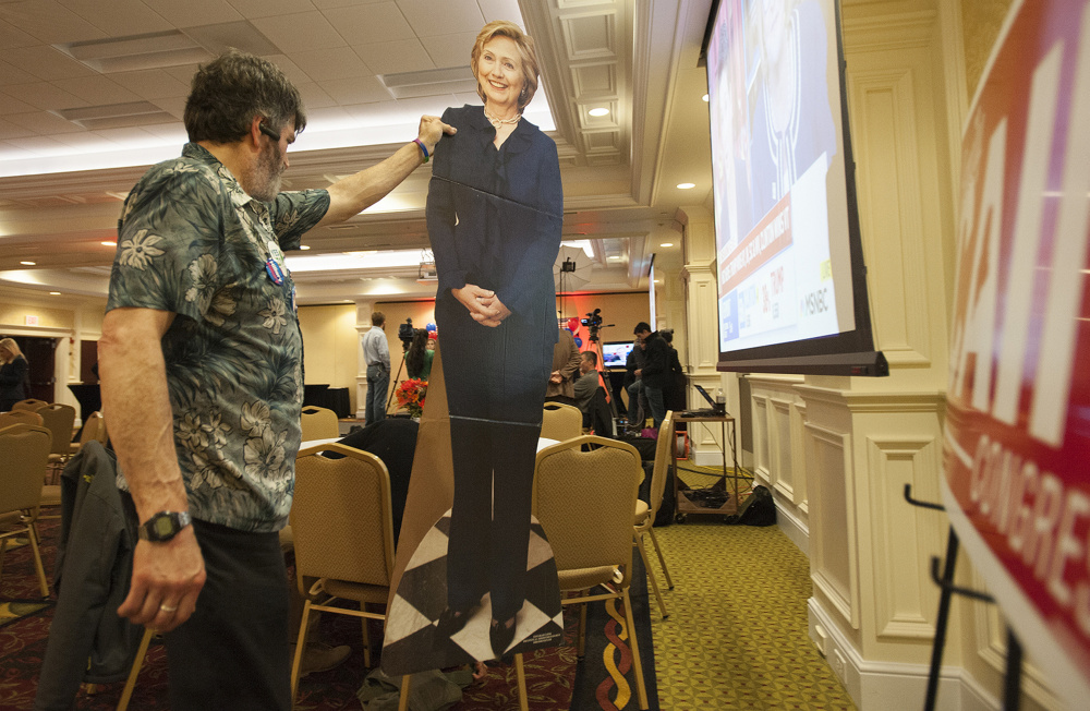 A man who would identify himself only as Harry carries a cardboard cutout of Hillary Clinton into the Hilton Garden Inn ballroom in Bangor Tuesday evening as supporters of Emily Cain started to gather to watch elections results.
