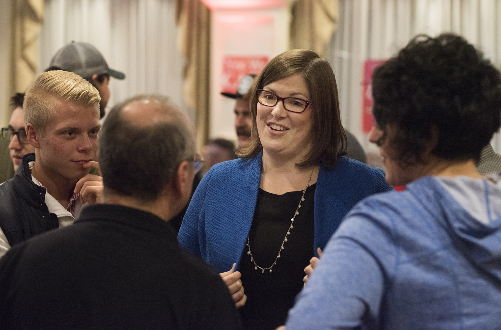Emily Cain greets and hugs supporters early Wednesday morning at the Hilton Garden Inn ballroom in Bangor.