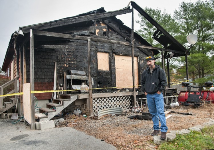 During an interview Wednesday, Jeffrey Sansouci stands outside his Randolph home, which was destroyed by fire Saturday. He credits working smoke detectors for getting him out of the building.