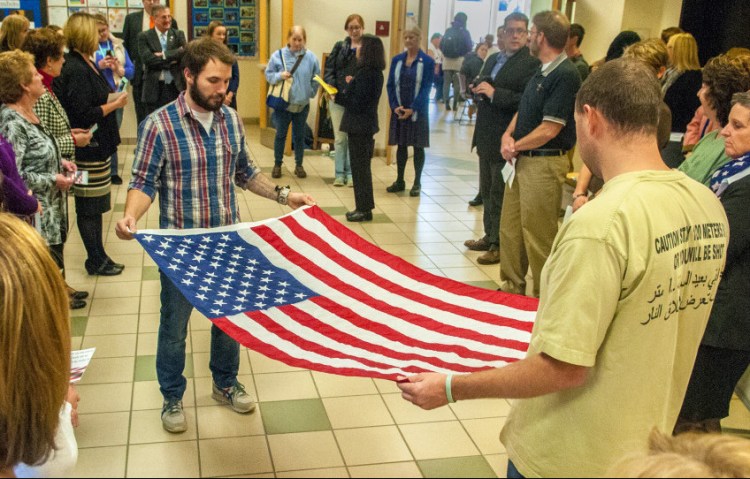 Nursing students Chad Ceccarini, left, an Air Force veteran, and Nicholas Whitmore, an Army veteran, fold a flag during a Veterans Day ceremony Thursday in the Randall Student Center at the University of Maine at Augusta. The flag was presented to nursing instructor Patricia Day and will be displayed in a nursing classroom. Cards written by students were presented to veterans, along with ice cream and cake at the event.