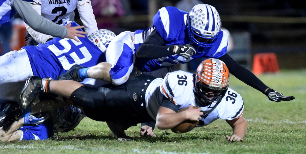 Winslow fullback Kenny Rickard dives for extra yards as Madison defender Max Shibley hauls him down during a Big Ten Conference semifinal game last Friday night at Rudman Field in Madison.