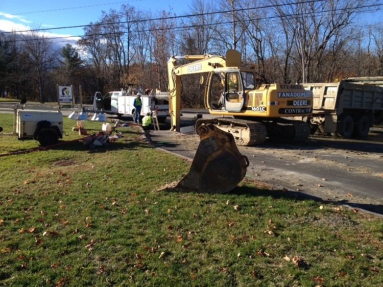 Kennebec Water District workers try to fix a broken water main Friday morning at the entrance to Quarry Road.