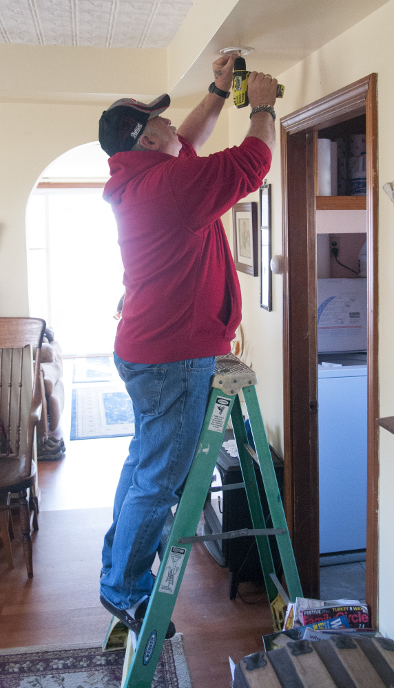 Randolph Fire Dept. Capt. Jim Kimball installs a smoke alarm on Saturday in a Randolph home.