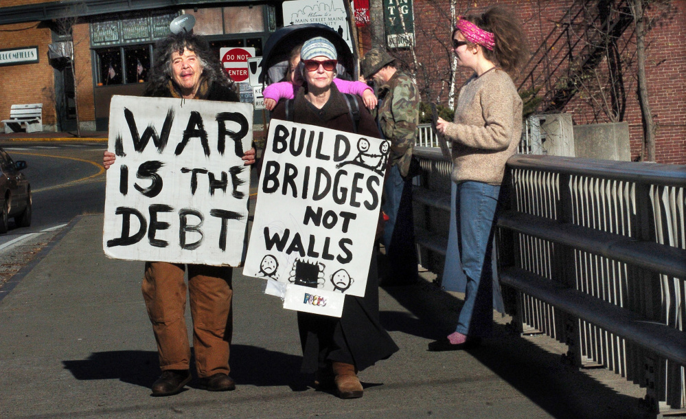 War protesters, from left, Abby Shahn, Lisa Savage and Selene Spivak and others hold signs Sunday on the Margaret Chase Smith bridge in Skowhegan.