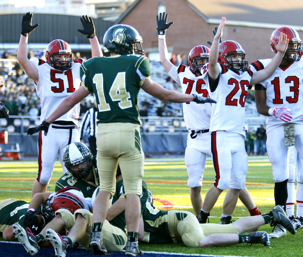 A host of Wells players signal for a touchdown during the Class C state championship game Saturday against Mount Desert Island at Fitzpatrick Stadium.