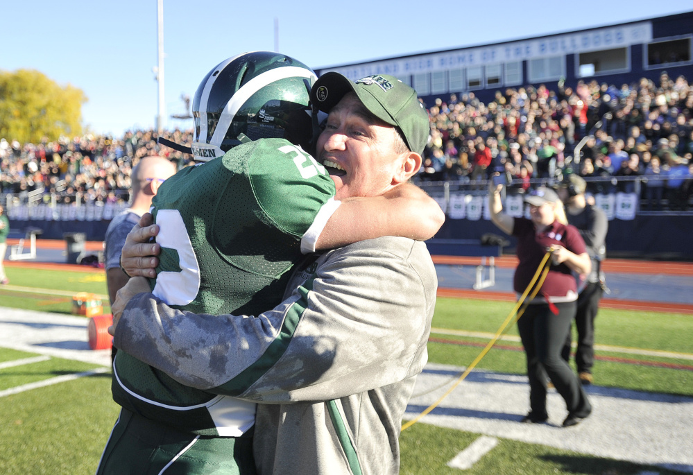 Bonny Eagle coach Kevin Cooper hugs Keith Hoffses after the Scots beat Portland for the Class A state championship Saturday afternoon at Fitzpatrick Stadium in Portland.