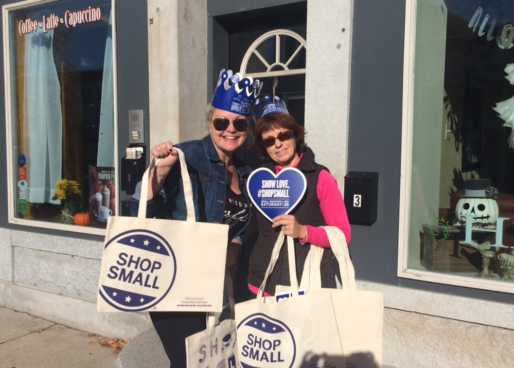 Winthrop Lakes Region Chamber Vice President and owner of Bloom Salon Kim Stoneton, left, and Chamber Executive Director Barbara Walsh hand out Shop Local bags and other items to promote Small Business Saturday and the Winthrop Region's Progressive Shopping Day on Nov. 26.