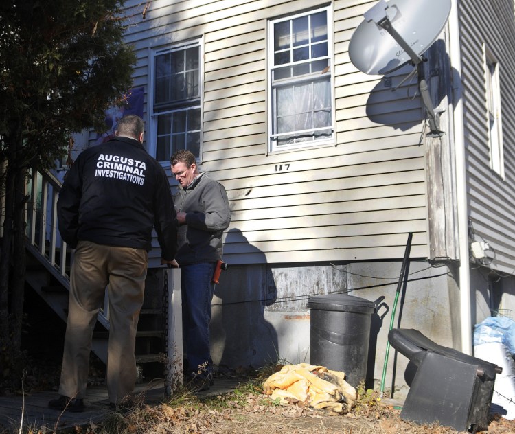 Augusta police Lt. Chris Massey, left, and Augusta Code Enforcement Officer Robert Overton conduct and inspection Wednesday at the apartment building at 117 Bridge St. in Augusta after police executed a search warrant there and arrested two people on drug trafficking charges.