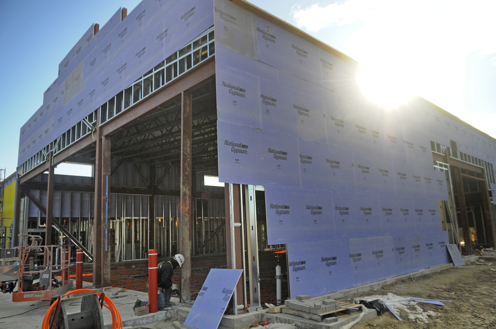 Workers build entrances for the bays at the new fire station Wednesday in Augusta.