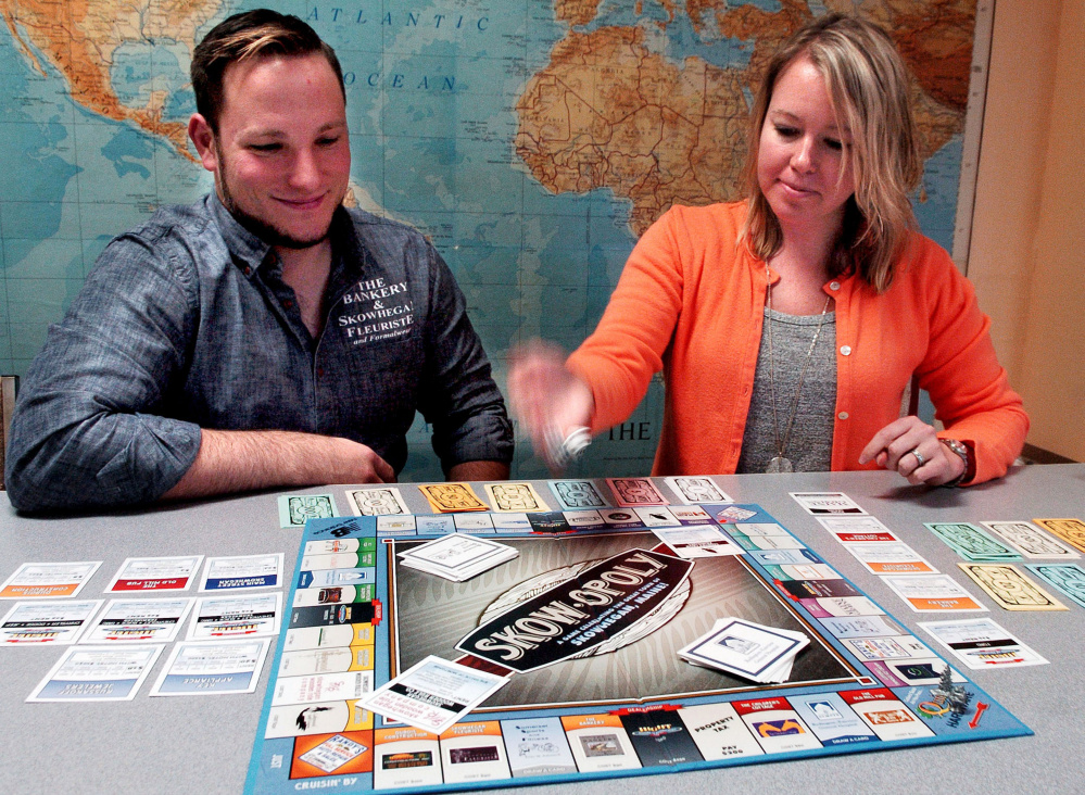 Matt DuBois, co-owner of The Bankery and president of the Main Street Skowhegan board, and Executive Director Kristina Cannon begin a game of the "Skowopoly" board game at the Skowhegan office on Wednesday.