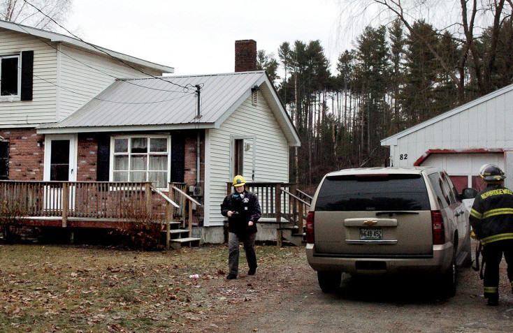 Office of the Maine State Fire Marshal investigator Mary MacMaster, left, and Norridgewock firefighters prepare to gather evidence Tuesday at a home at 82 Mechanic St. in Norridgewock that was damaged by fire the previous night.