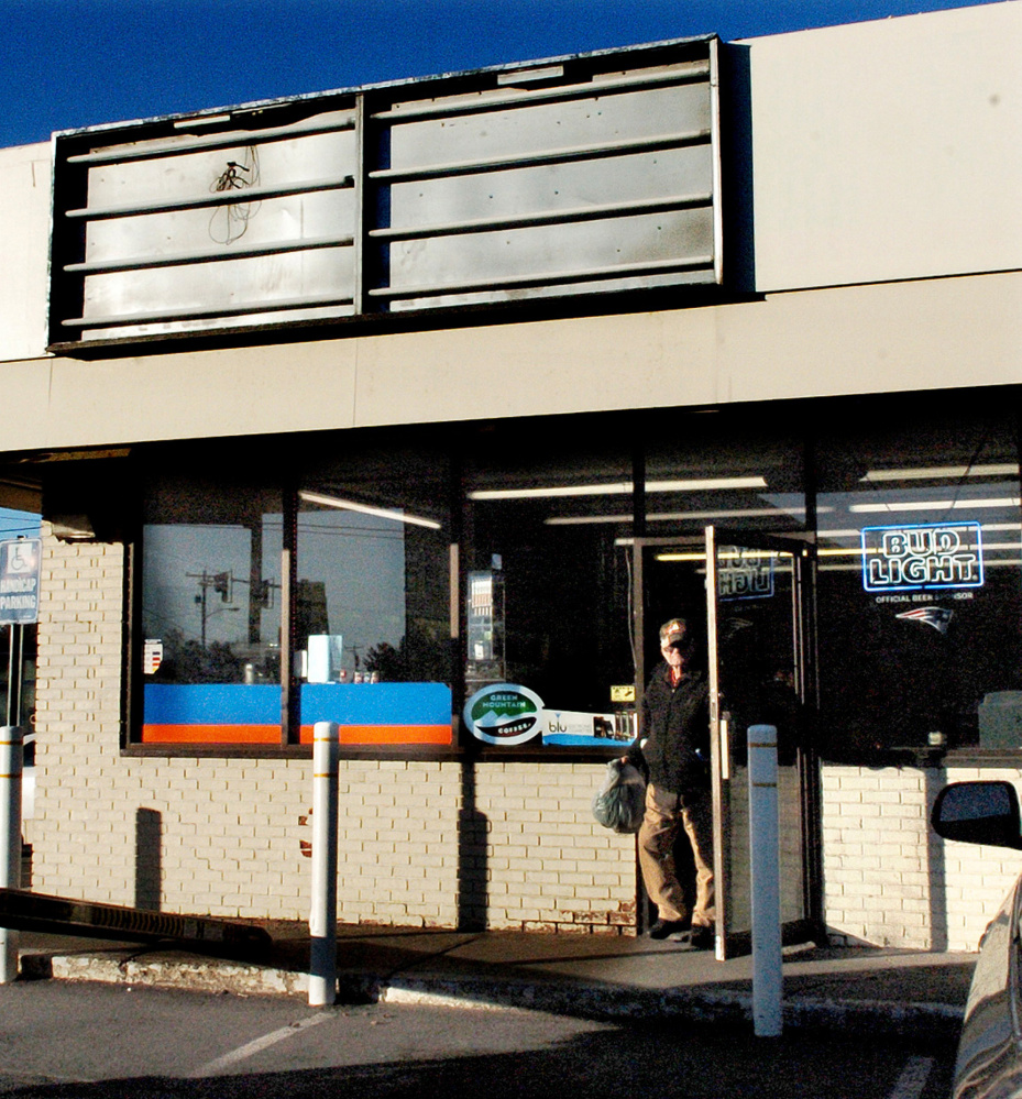 A customer on Monday leaves the former Cumberland Farms store in Madison where the sign, top, was removed after it was purchased from the franchise by owner Ramesh Patel. The new store is called Country Farm 2.