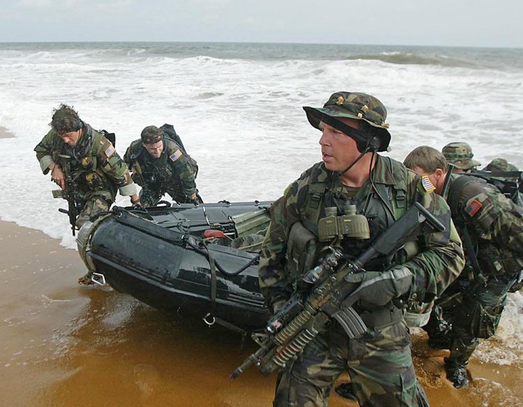 Navy Seals, under the direction of the Joint Special Operations Command, land on the beach in Monrovia, Liberia, in this 2003 photo. Some in the Pentagon hope to see the new task force working in tandem with the CIA. <em>Associated Press/Schalk van Zuydam</em>