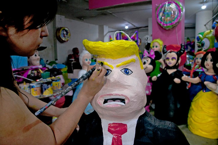 Alicia Lopez Fernandez paints a pinata depicting Donald Trump at her family's store "Pinatas Mena Banbolinos" in Mexico City in this July 10, 2016, photo. Marco Ugarte/Associated Press