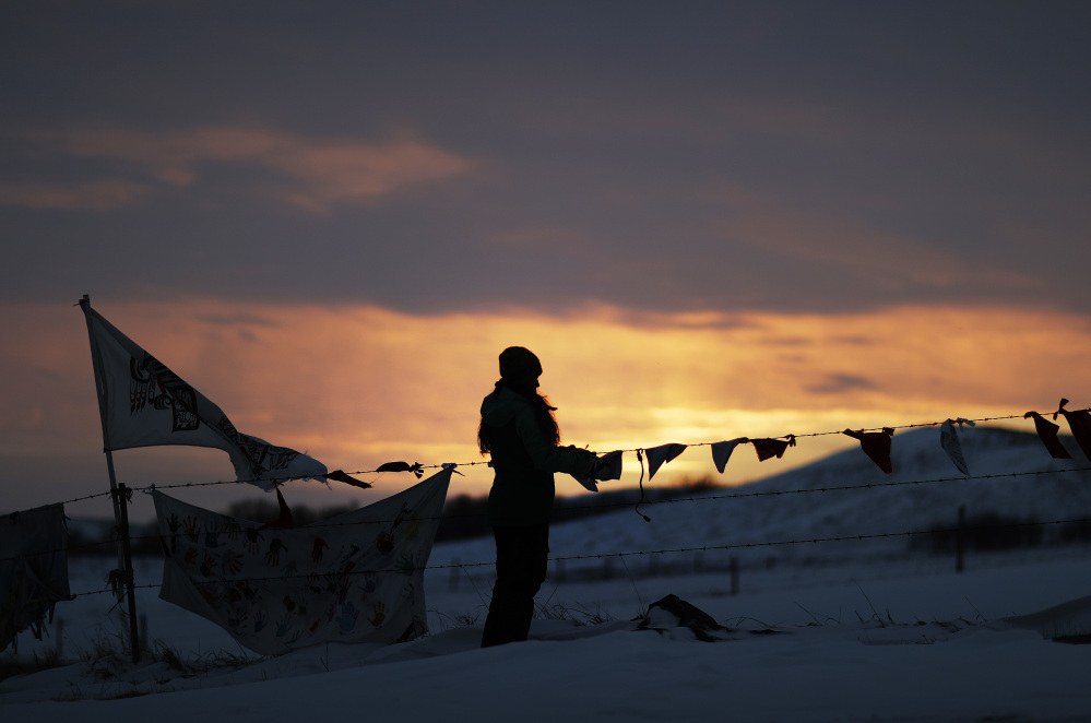 A woman watches the sunset at the Oceti Sakowin camp where people have gathered to protest the Dakota Access oil pipeline in Cannon Ball, N.D., Friday.