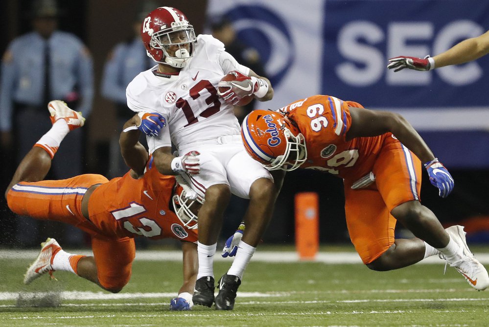 Alabama receiver ArDarius Stewart is hit by Jachai Polite, left, and Daniel McMillian of Florida after making a catch during the second half of the Southeastern Conference championship game Saturday in Atlanta. Alabama won 54-16 and is expected to return to Atlanta on Dec. 31 for a national semifinal.