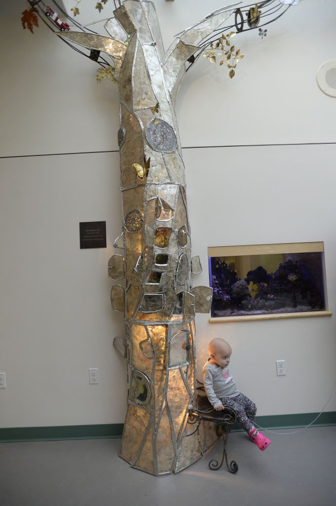 Patient Madison Arndt sits in a small chair that is part of the stained-glass tree installed in the children's hospital atrium. "She likes exploring it, looking in every door and seeing what she can find," said her father, Mitchell Arndt. "It's pretty amazing. Lots of colors."