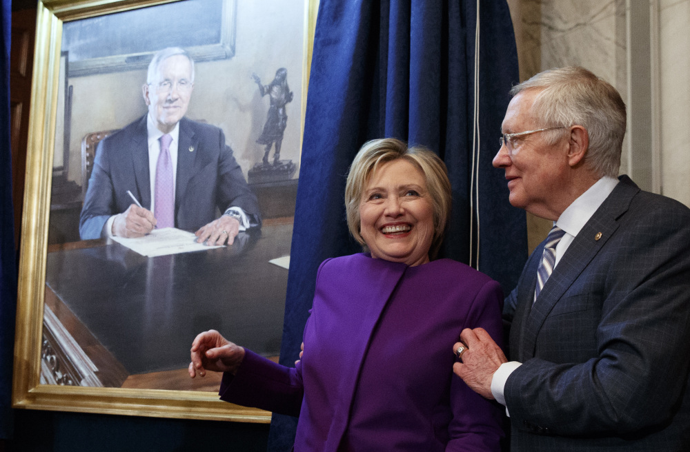 Hillary Clinton smiles as Senate Minority Leader Sen. Harry Reid poses her for a photograph during a farewell ceremony to unveil a portrait of Reid on Capitol Hill on Thursday.