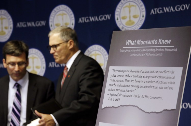 Washington Attorney General Bob Ferguson, left, and Gov. Jay Inslee announce a lawsuit against agrochemical giant Monsanto over pollution from polychlorinated biphenyls, or PCBs, in Seattle on Thursday.