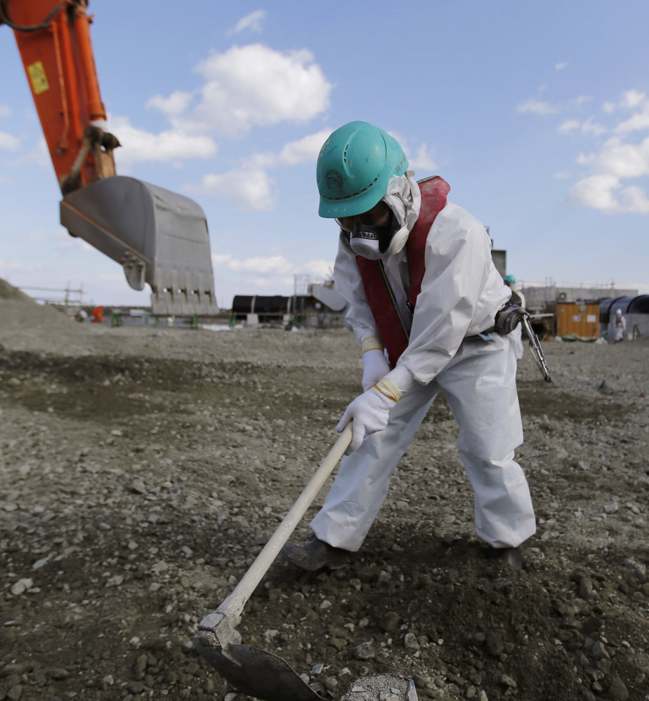 In February a worker levels ground at the crippled Fukushima Dai-ichi nuclear power plant.