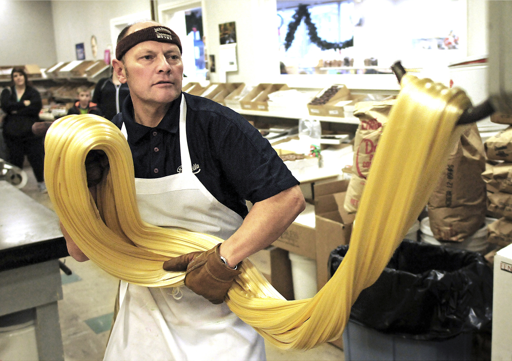Priscilla Candy Shop owner James Gallant stretches out a batch of candy cane mix at the store in Gardner, Mass. Workers prepare them each year right after Thanksgiving. Gallant said he has made about 50,000 candy canes since he joined the business 31 years ago.