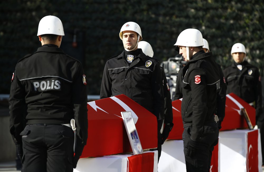 Turkish police officers stand guard Sunday next to flag-draped coffins of colleagues killed by bomb blasts Saturday outside an Istanbul stadium.