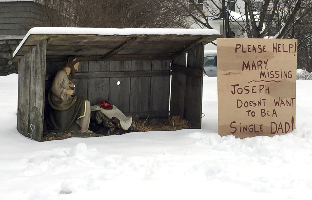 A handwritten, cardboard sign next to a nativity scene in Manchester, N.H., displays a message Monday for whomever stole the statue of Mary last week.