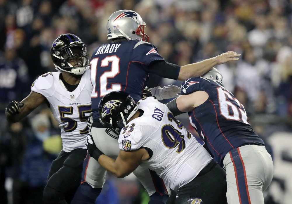 Ravens defensive end Lawrence Guy hits Tom Brady as he throws an interception in the first half. It was just the second interception of the season for Brady, but it was the first of three turnovers for the Patriots.