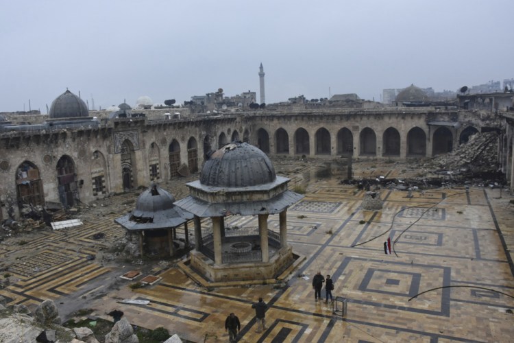 Syrian troops and pro-government gunmen walk inside the destroyed Grand Umayyad mosque in the old city of Aleppo, Syria, on Tuesday. Government forces and rebel fighters have fought to control the 12th-century mosque for the last four years, until Syrian troops seized control of it this week.