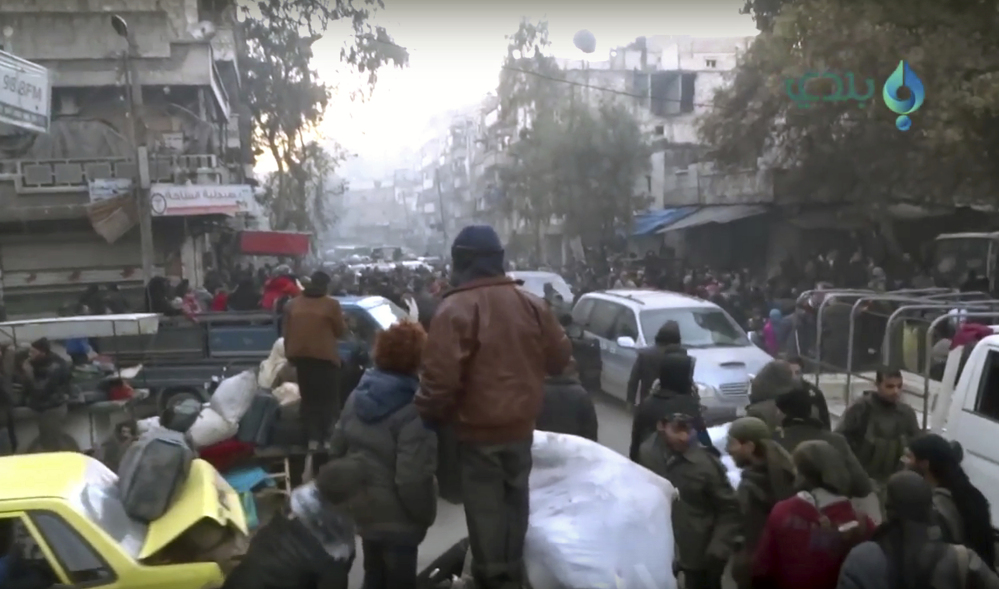 This image taken from video shows civilians gathering for evacuation from eastern Aleppo, Syria, on Thursday.